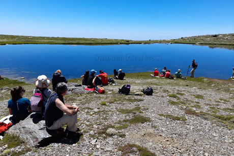 grupo de senderistas en un lago de sierra nevada