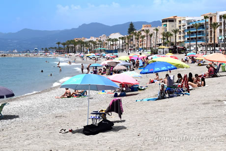 sombrillas de mucha gente en la playa de torrenueva