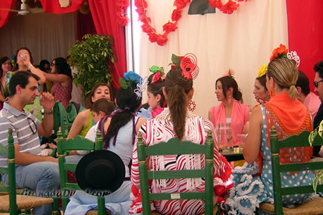 mujeres vistidos de flamenco en la caseta en la feria de granada